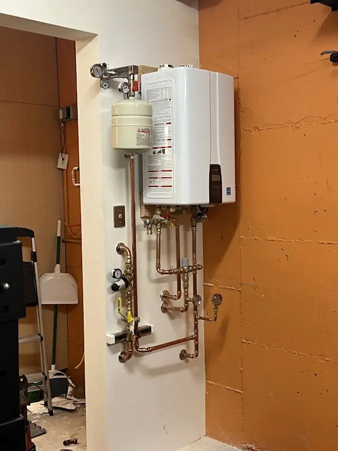 Plumbing technician inspecting water heater connections in Cloverdale